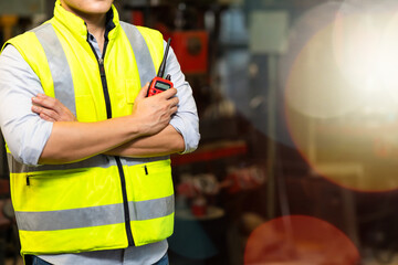 Factory engineering manager asian man Working and holding radio walkie talkie at Metal lathe industrial manufacturing factory. Portrait of  Engineer Operating lathe Machinery.