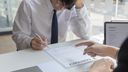 Man is signing a contract with the company, Supervisor orders the employee to sign the resignation document, End of the employment contract or termination of employment.