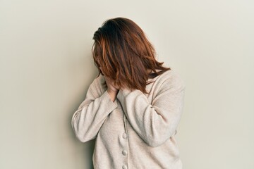 Young caucasian woman wearing casual clothes with sad expression covering face with hands while crying. depression concept.