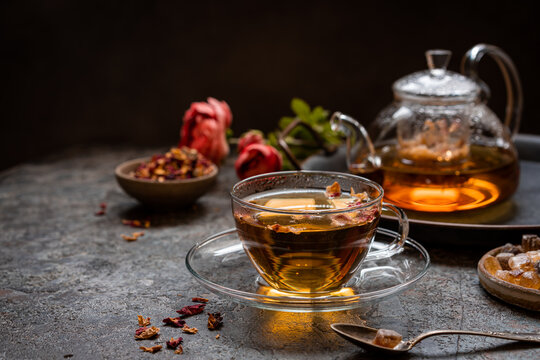 herbal flower tea from the petals of rose in a glass cup on dark gray background