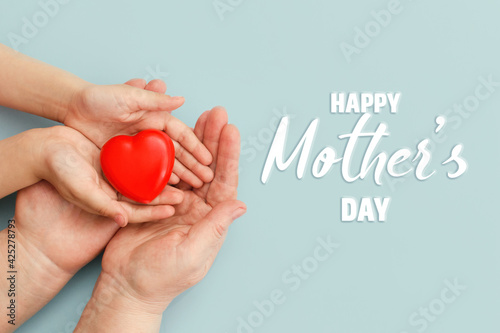 Concept Happy Mother's Day or International Day of Families.Happy women's day.Heart in the hands of daughter and mother on a blue background.I love you.Banner for store.Greeting card. Top view. banner