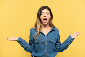 Young Russian girl isolated on yellow background with shocked facial expression