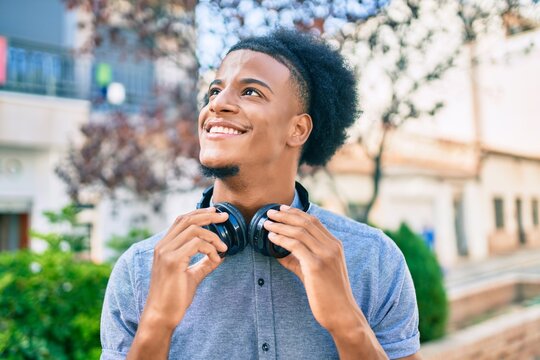 Young african american man listening to music using headphones at the city.