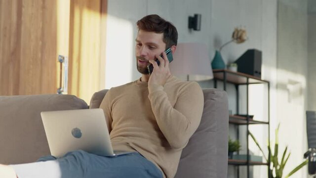 Young man talking on the phone at home office