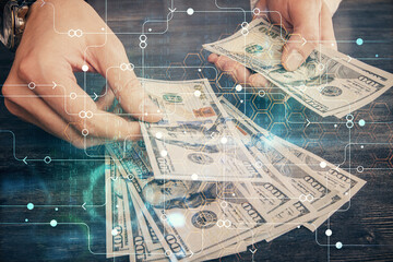 Double exposure of technology drawing hologram and us dollars bills and man hands. Data concept