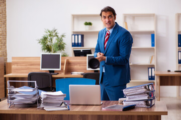 Young male employee holding plunger in funny concept