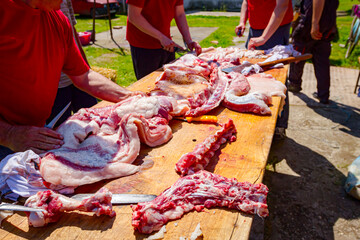 Butcher is cutting, processing fresh meat