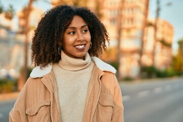 Young african american woman smiling happy standing at the city.