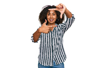 Obraz na płótnie Canvas Young african american girl wearing casual clothes smiling making frame with hands and fingers with happy face. creativity and photography concept.