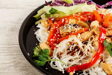 Japchae, Korean glass noodle stir fry. Korean glass japche noodles with stewed chicken with sesame vegetables and sauce on a white background.  Top view. Japchae Asian cuisine. Funchose