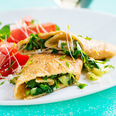 Omelette rolls on a plate. Homemade fried omelet rolls with chopped greens. Healthy low carb recipe.