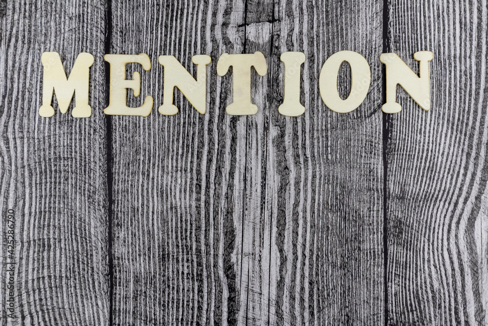 Fototapete mention concept with alphabet letters on cubes over old rustic wood with woodgrain pattern and copys