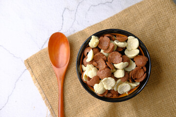  Top view of corn flakes in a bowl on table 