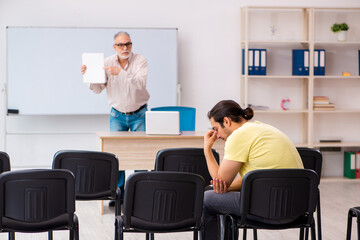 Young male student and experienced teacher in pandemic concept