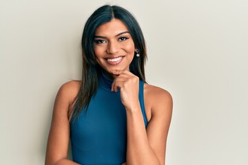 Young latin transsexual transgender woman wearing casual clothes smiling looking confident at the camera with crossed arms and hand on chin. thinking positive.