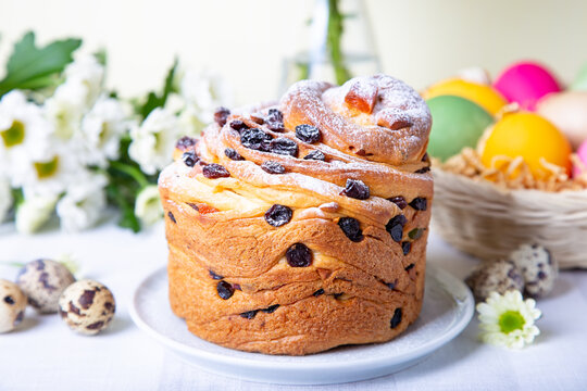 Craffin (Cruffin) with raisins and candied fruits. Easter Bread Kulich and painted eggs. Easter Holiday. Close-up.