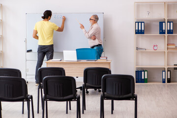 Young male student and experienced teacher in pandemic concept