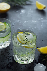 Detox drink with lemons, fresh cucumber and honey . Summer cold, refreshing cocktail drink. Dark background.