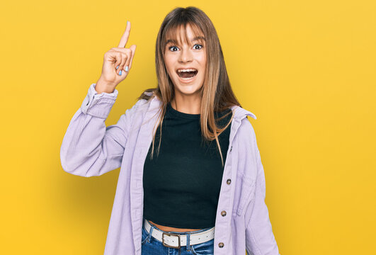 Teenager caucasian girl wearing casual clothes pointing finger up with successful idea. exited and happy. number one.