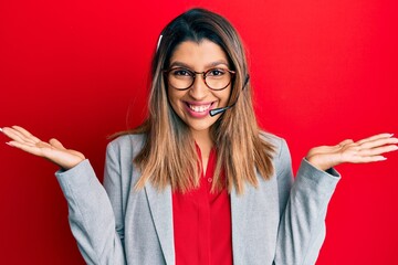 Beautiful brunette woman working at the office wearing operator headset celebrating victory with happy smile and winner expression with raised hands