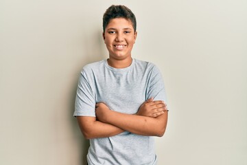 Teenager hispanic boy wearing casual grey t shirt happy face smiling with crossed arms looking at...