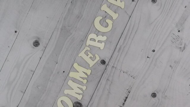 Commercial - concept with skewed alphabet letters arranged as the bottom border on a grey wooden plank background with copyspace. Rotating table