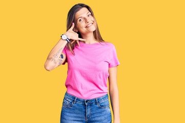 Beautiful caucasian woman wearing casual clothes smiling doing phone gesture with hand and fingers like talking on the telephone. communicating concepts.