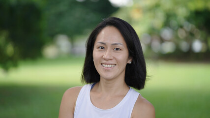 Asian chinese woman smiling sweetly outdoors garden active sporty