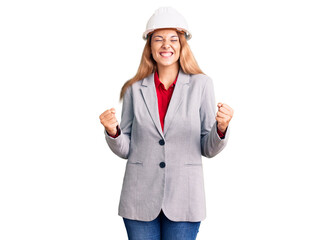 Beautiful young woman wearing architect hardhat excited for success with arms raised and eyes closed celebrating victory smiling. winner concept.