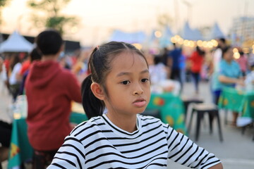 Asian children sitting and eating in the food festival at daytime