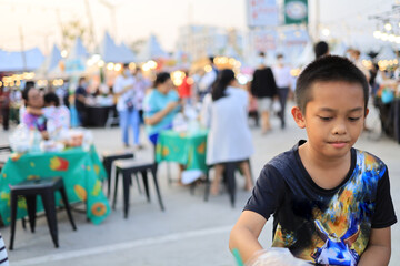 Asian children sitting and eating in the food festival at daytime
