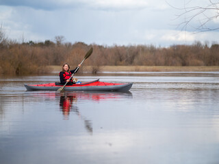 A girl and a little puppy are sailing on a kayak