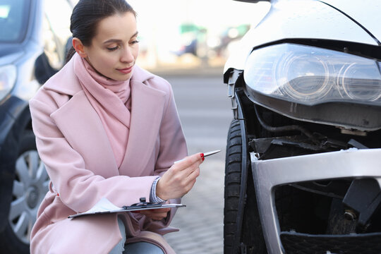 Insurance agent holds estimate of the value of damaged vehicle