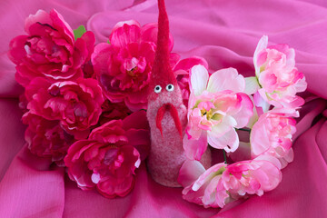 Pink themed flat lay still life with cute felt handmade toy and silk flowers