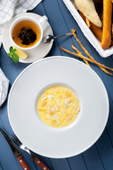 Corn porridge (polenta) with almonds and gorgonzola cheese in a white plate. Healthy breakfast, top view