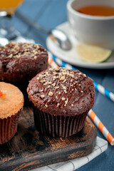Homemade chocolate cupcake with nuts on the table with tea. Chocolate covered muffin
