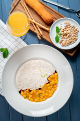 Oatmeal porridge with mango and nuts for breakfast. Healthy diet food, top view