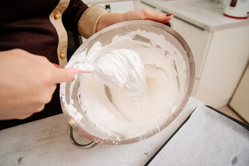 The process of making a meringue roll. The pastry chef prepares a meringue roll. Cooking meringue roll in the kitchen. The pastry chef whips up the protein cream.