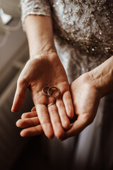 the bride holds wedding rings in her hands