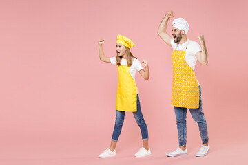Full length side view of teen fun girl dad man father's helper chef cook confectioner baker in...