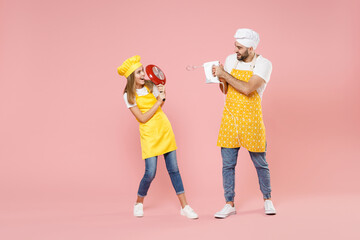 Full length teen fun girl dad father's helper chef cook confectioner baker in yellow apron cap hold...