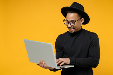 Young freelancer smiling copywriter african man 20s wear stylish black shirt hat eyeglasses using...