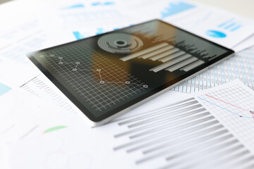 Tablet with business indicators in charts is on desktop