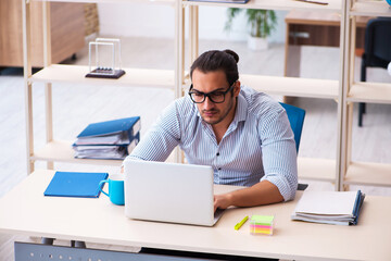 Fototapeta premium Young male employee working in the office