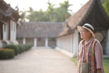 old elderly elder woman traveller traveling in asian temple. senior leisure lifestyle