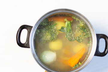 Boiling vegetables carrot, onion, potato, Brussels sprouts for soup in pot