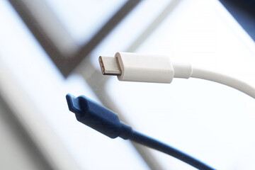 White usb type-c connector over dark reflective background. Minimalism. A modern way to connect, transfer data and charge gadgets. Close-up. Macro