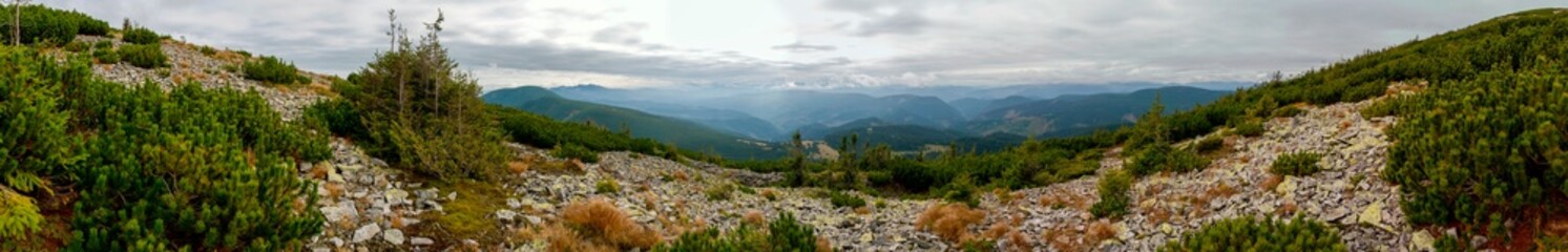 Panorama of mountain peaks. Panorama of rocky placers and storm clouds