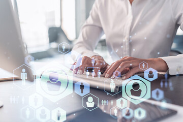 HR woman specialist is typing the keyboard in the internet to find the best candidates to create international network in recruitment process. Formal wear. Social media hologram icons.