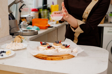 Cake Anna Pavlova. The process of making a cake Anna Pavlova. The pastry chef decorates the cake Anna Pavlova. Making a cake Anna Pavlova.